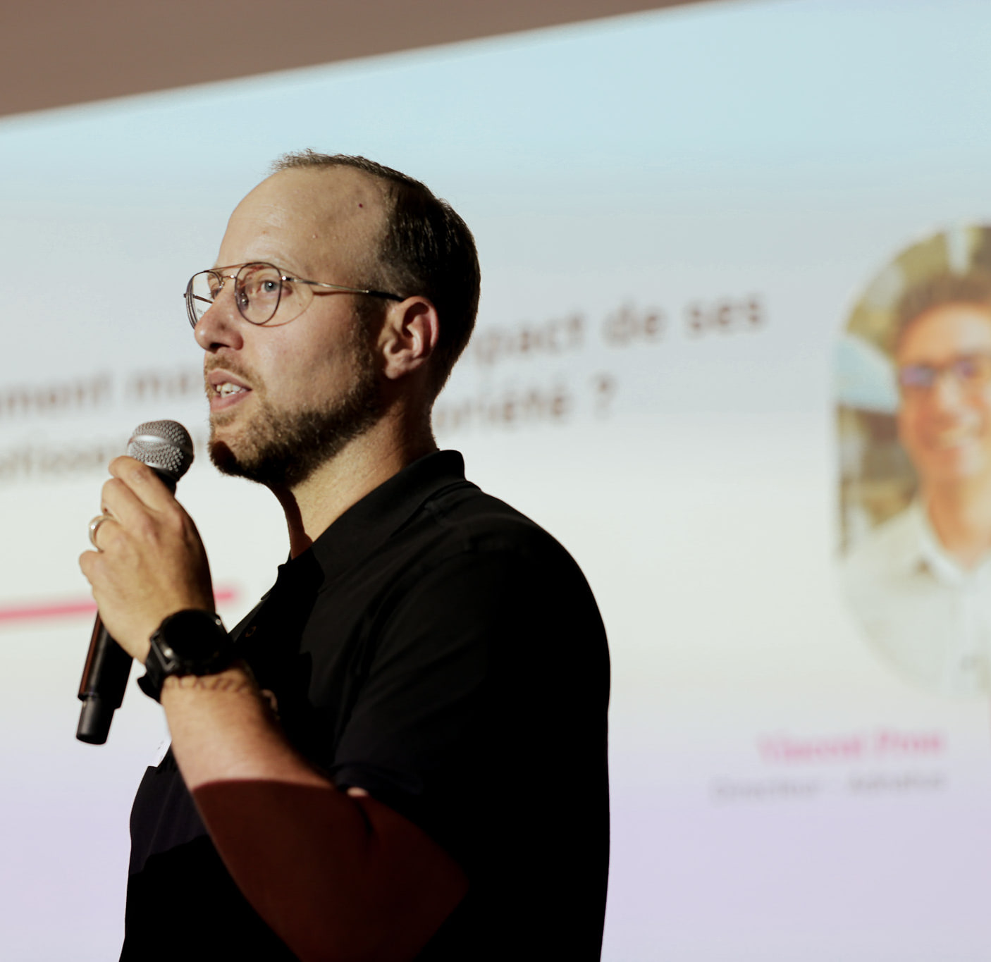 Un intervenant au micro devant une diapositive consacrée à la mesure de l’investissement publicitaire.