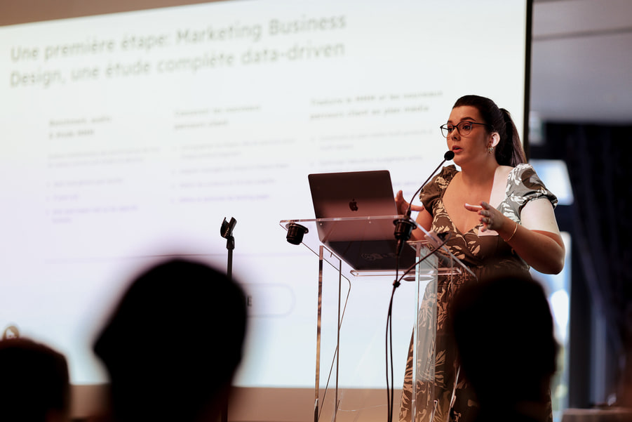 Une intervenante devant une diapositive sur le marketing business design.