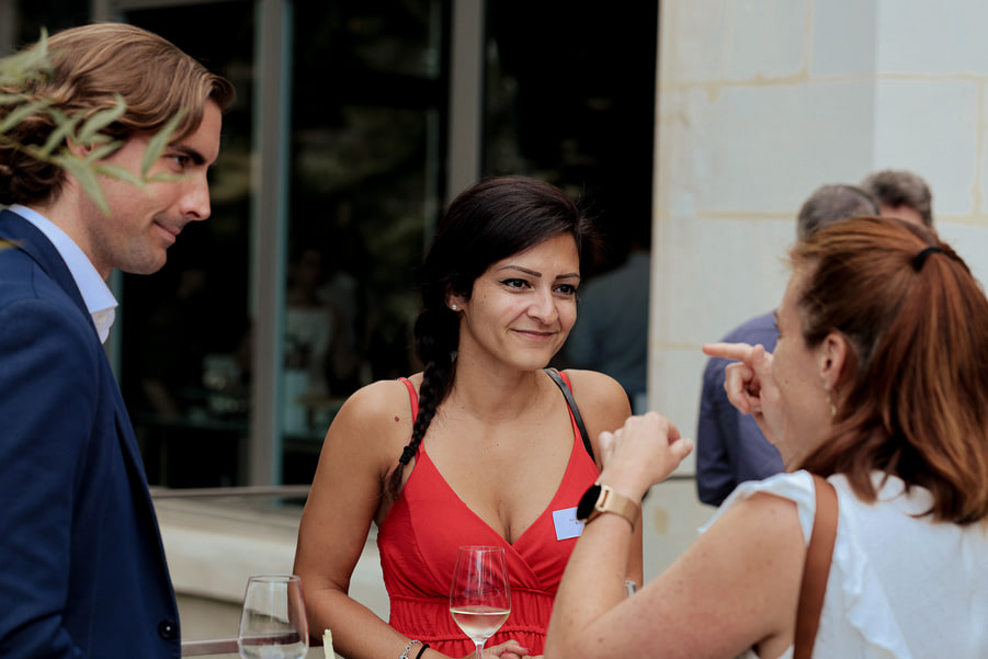 Des participants discutent, verre à la main, pendant la réception.