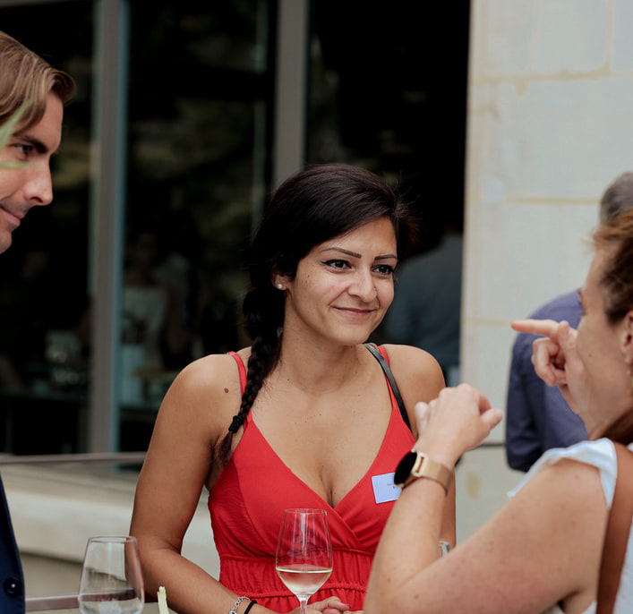 Deux participants discutent, un verre à la main, pendant la réception.