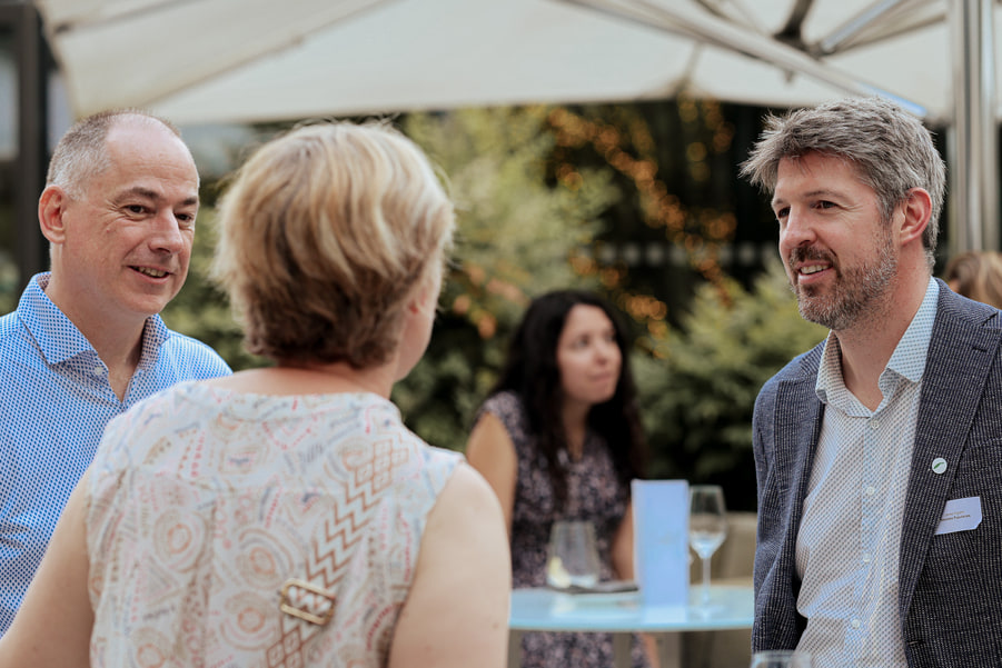 Quatre participants en conversation sous la tente du jardin.