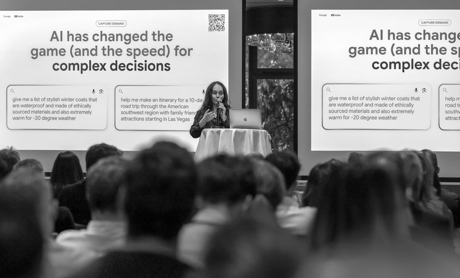 Photo en noir et blanc du public devant l’écran : « AI has changed the game (and the speed) for complex decisions ».