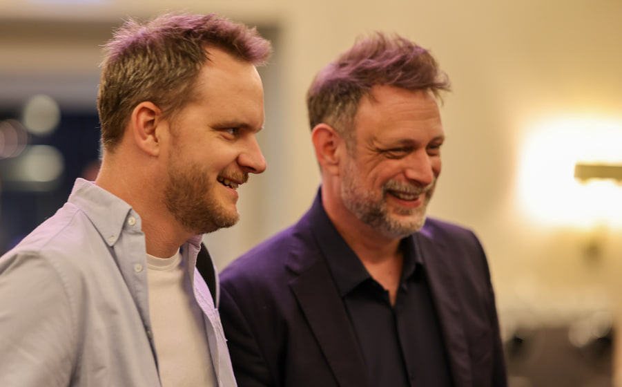 Deux participants en conversation pendant le cocktail.