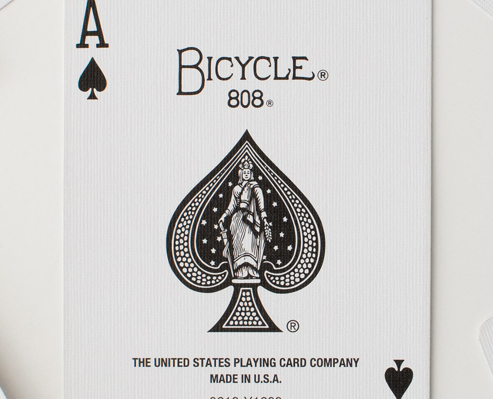 L’as de pique d’un jeu Bicycle, face visible au milieu de cartes retournées.