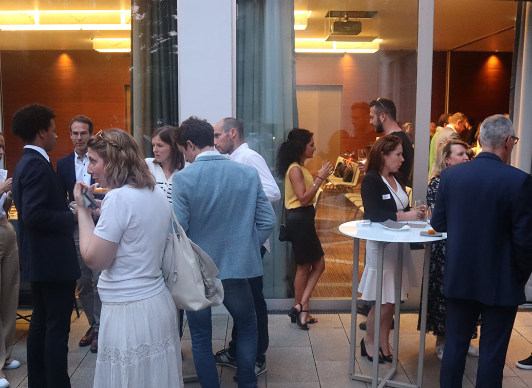 Le cocktail : les participants debout autour des tables hautes.