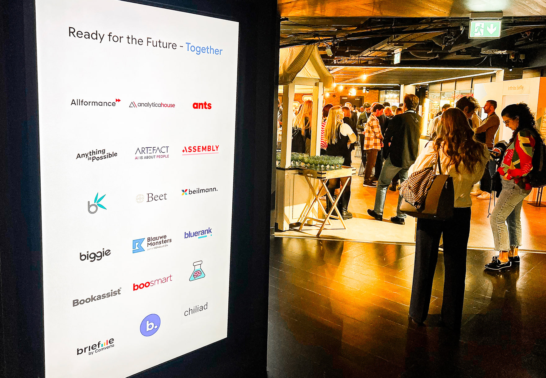 Panneau « Ready for the Future — Together » couvert de logos d’agences, et l’accueil des participants dans le hall.