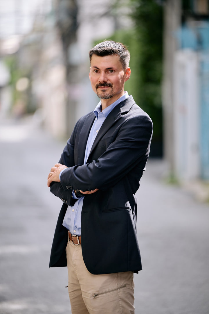 Damien Magnenat, les bras croisés, dans une rue.